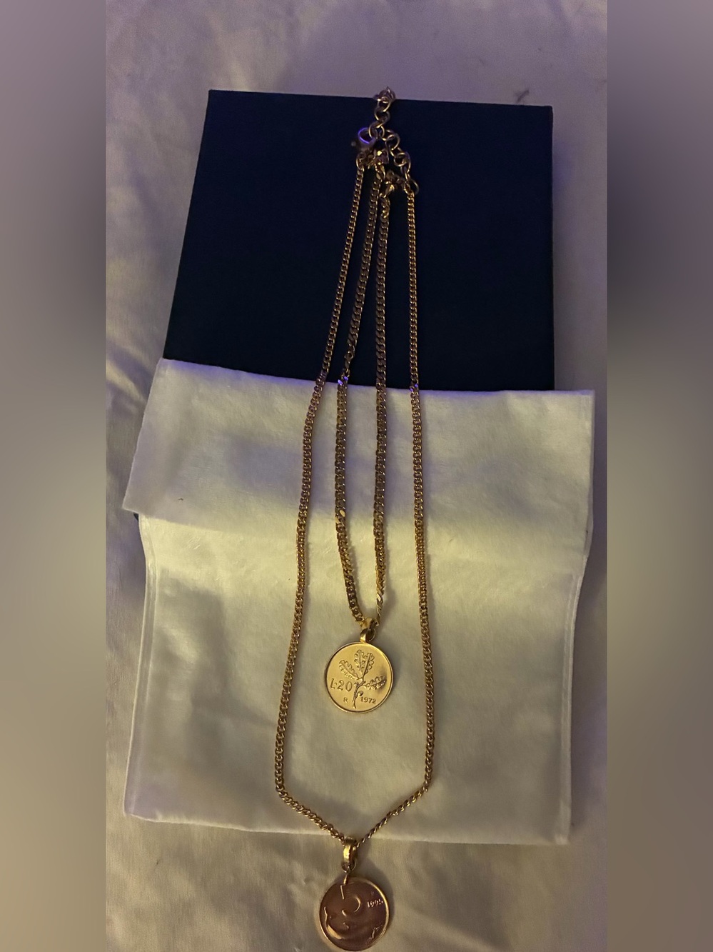 GOLD TONE DOUBLE CHAIN NECKLACE WITH TWO CIRCULAR COIN-LIKE PENDANTS.